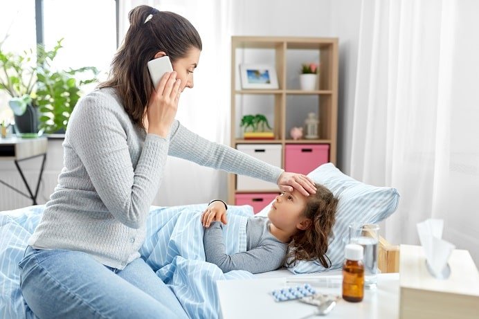 mãe com criança deitada na cama com vírus sincicial respiratório